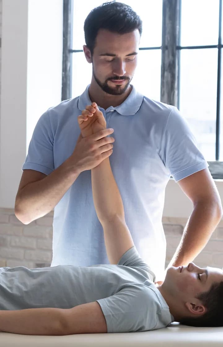 Therapist guiding a patient's arm during a mobility treatment session
